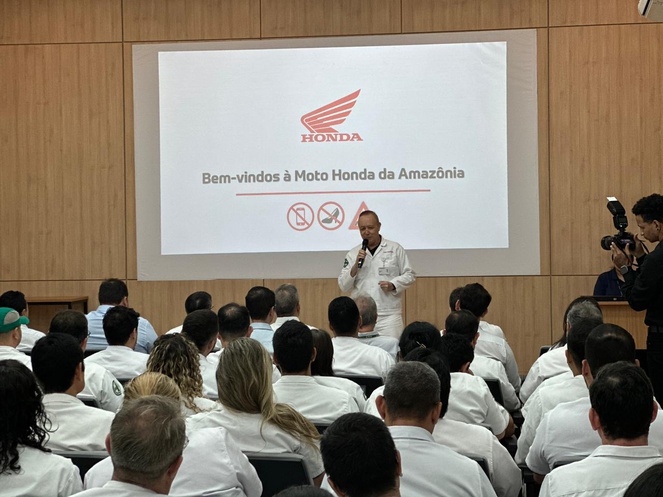 Foto mostra homem em pé falando em evento público