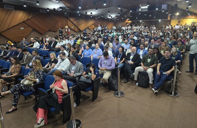 Foto mostra auditório lotado em um evento