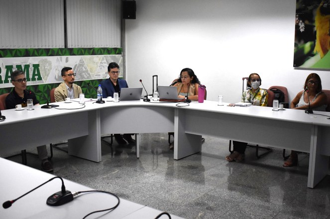 Foto mostra homem de óculos e blusa escura falando durante uma por videoconferência