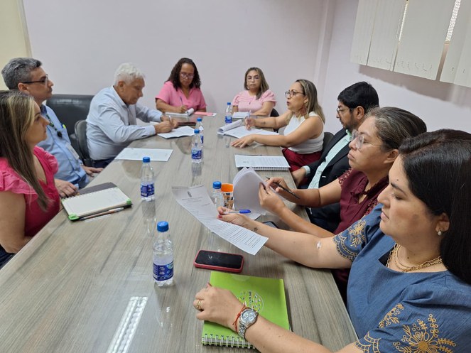 Foto mostra pessoas reunidas numa mesa