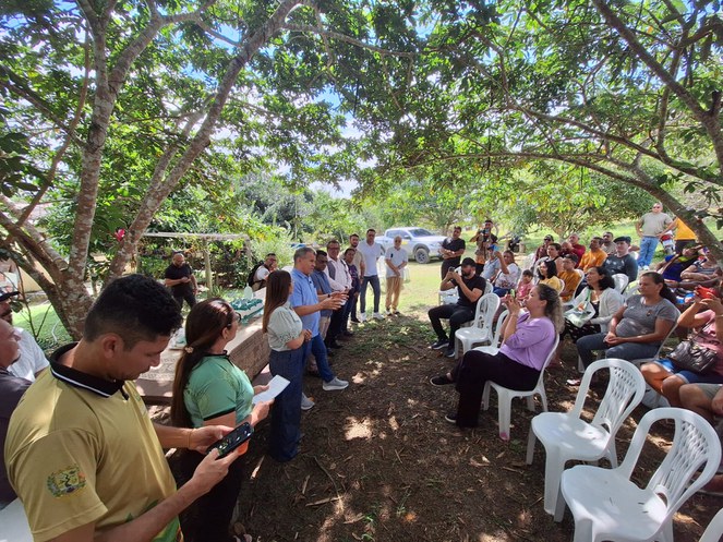 Foto mostra um homem de blusa azul falando a um público