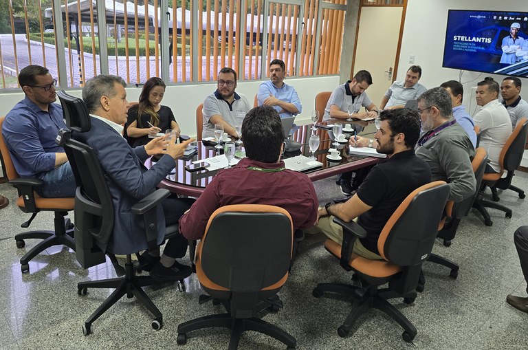 Foto mostra homem gesticulando durante explanação numa reunião com outras pessoas