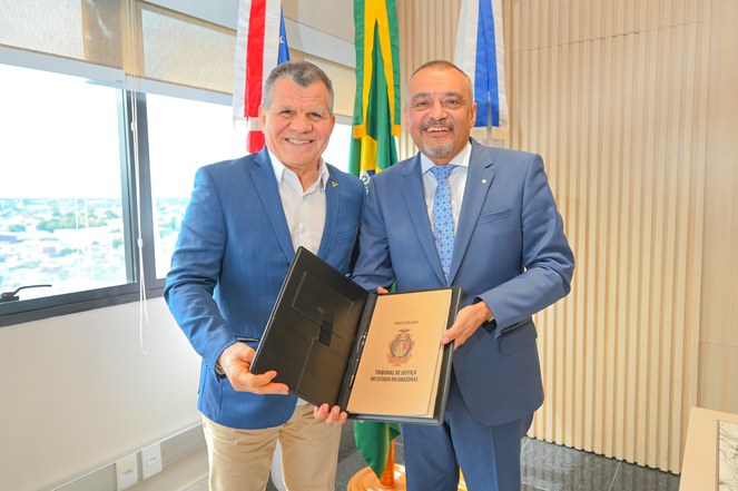 Foto mostra duas autoridades segurando uma publicação