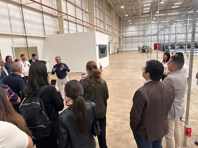 Foto mostra pessoas dentro de uma fábrica