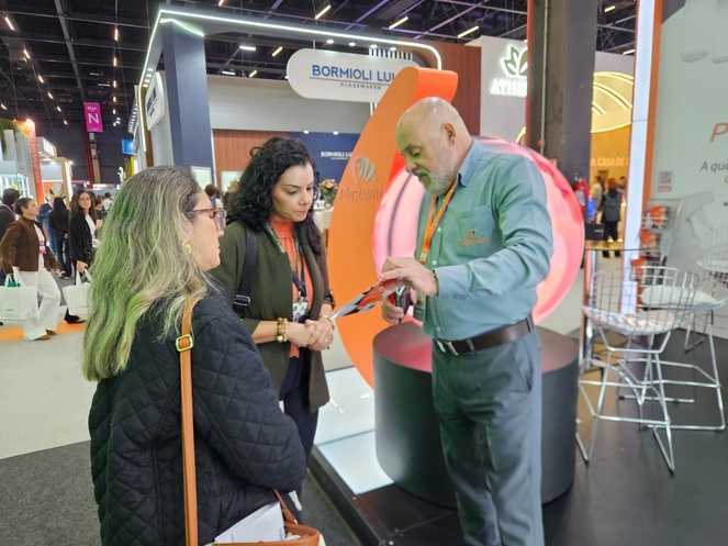 Foto mostra homem mostrando material informativo para duas mulheres