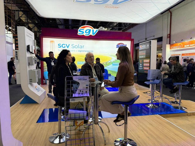 Foto mostra três pessoas reunidas em uma mesa