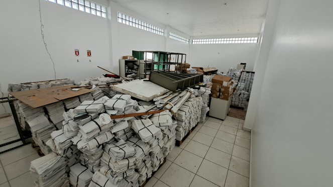 Foto mostra uma sala com papeis que seriam descartados para coleta seletiva