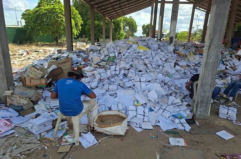 Foto mostra pessoas fazendo coleta seletiva de papel