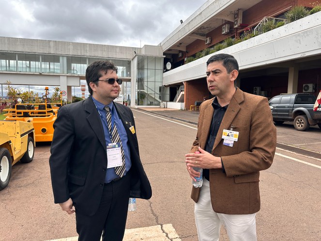 Foto mostra dois homens de blazer conversando