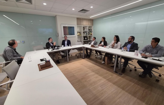 Foto mostra pessoas sentadas numa reunião