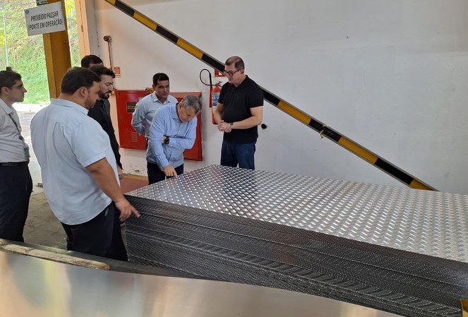 Foto mostra homem pegando em um material de alumínio