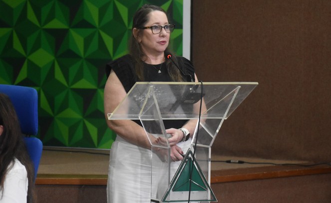 Foto mostra mulher falando em frente a um púlpito