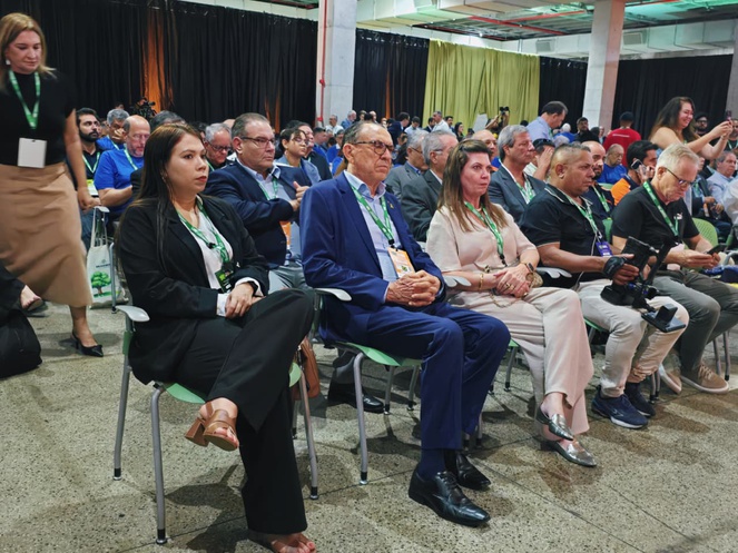Foto mostra pessoas sentadas em um evento concorrido