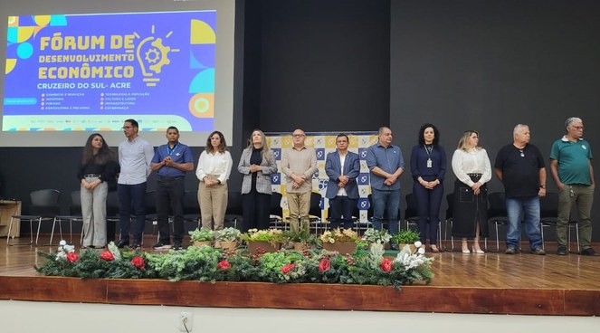 Foto mostra grupo de pessoas posando para foto durante evento