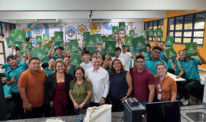 Foto mostra grupo de pessoas com papel na mão