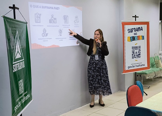 Foto mostra mulher apontando informaçõe apresentadas por um slide
