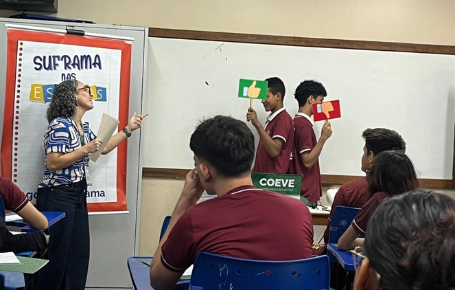 Foto mostra dois rapazes segurando duas plaquinhas