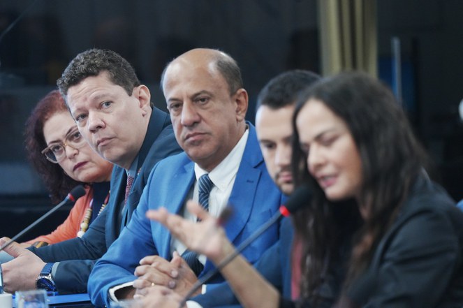 Foto mostra pessoas participando de reunião