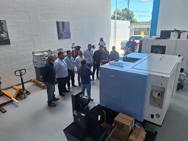 Foto mostra pessoas e máquinas durante visita a uma empresa de peças para motocicletas