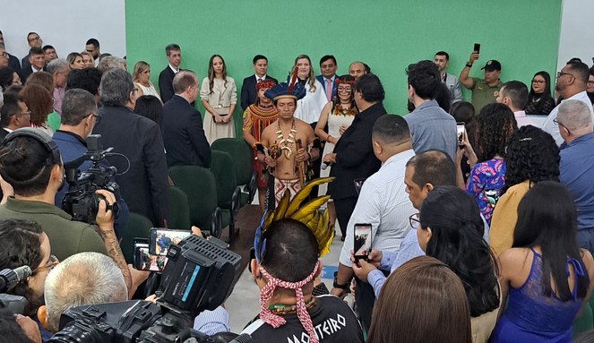 Foto mostra indígena fazendo ritual em um evento entre universitários
