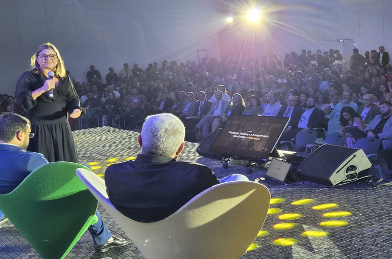 Foto mostra mulher falando em evento público