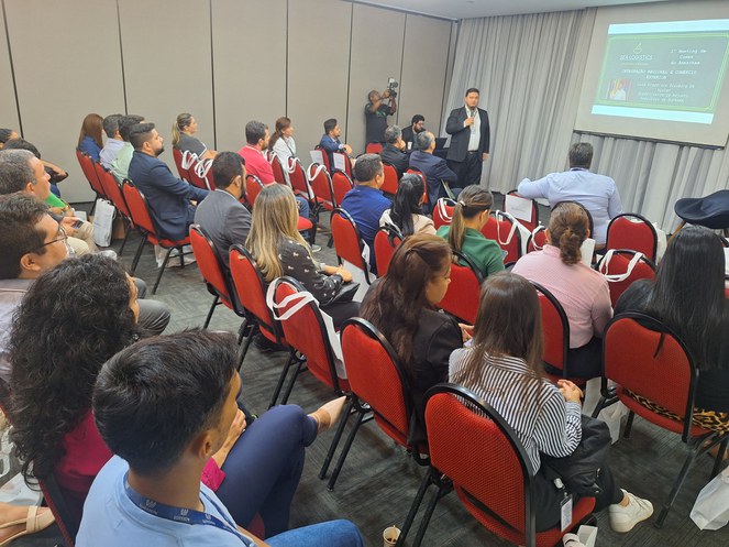 Foto mostra homem de paletó e blusa pretos ministrando palestra a um grupo de pessoas