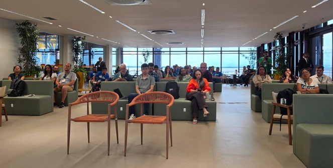 Foto mostra grupo de pessoas assistindo a um debate