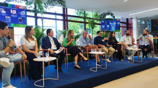 Foto mostra grupo de pessoas debatendo em um evento