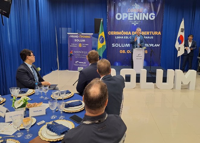 Foto mostra homem em pé falando em um evento