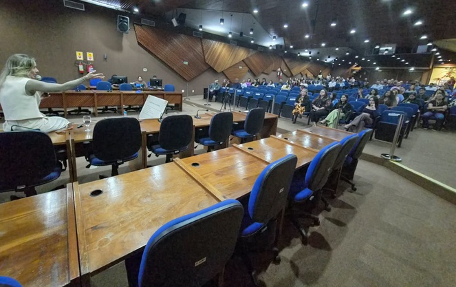 Foto mostra pessoas em um auditório durante uma palestra