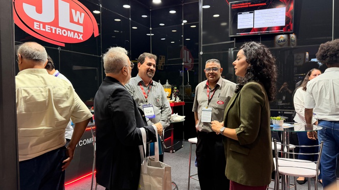 Foto mostra quatro pessoas conversando, sendo uma mulher entre eles