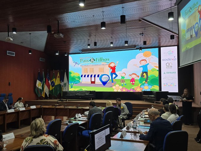 Foto mostra evento em um auditório com painel como apoio