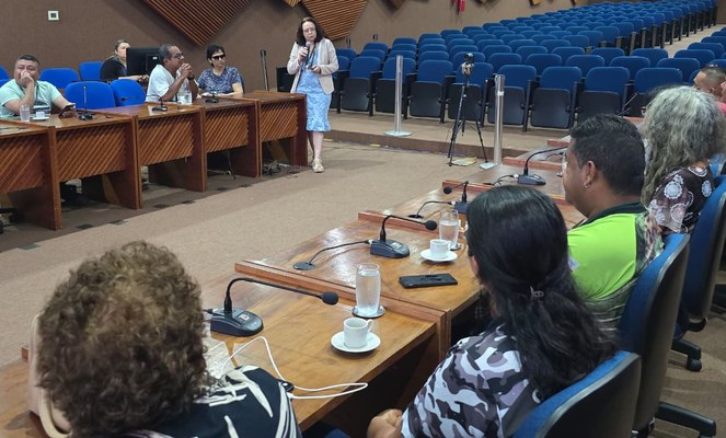 Foto mostra mulher em pé falando em um evento