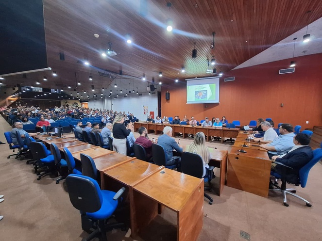 Foto mostra pessoas em um auditório lotado