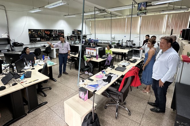 Foto mostra pessoas visitando um laboratório de informática