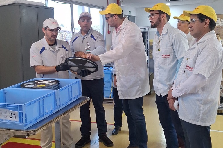 Foto mostra pessoas tocando num equipamento eletrônico