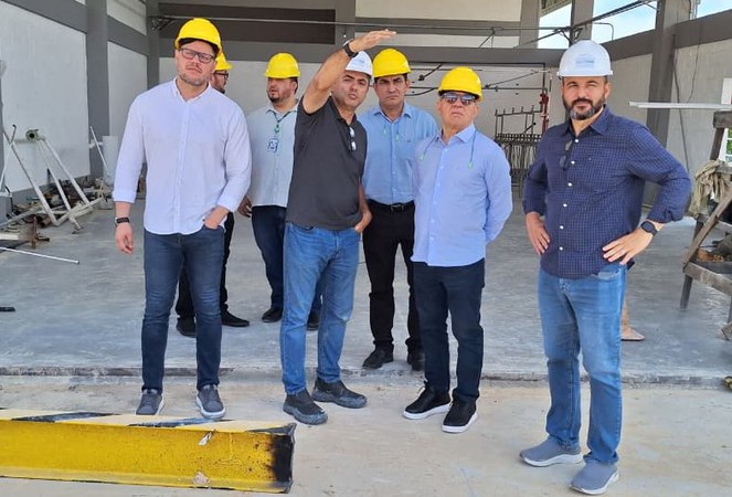 Foto mostra homem com capacete em visita a uma empresa