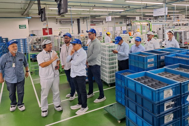 Foto mostra homem explicando a outros homens o funcionamento de uma empresa, durante visita técnica