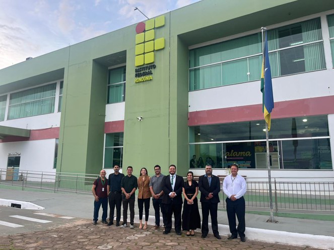 Foto mostra pessoas posando para foto em frente a um prédio