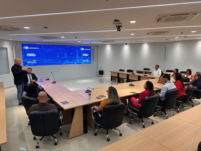 Foto mostra homem em pé falando a grupo de pessoas