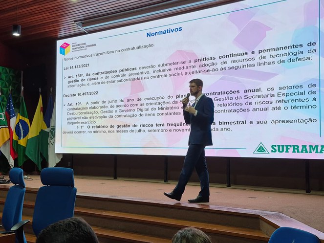 Foto mostra homem fazendo uma palestra tendo telão como apoio