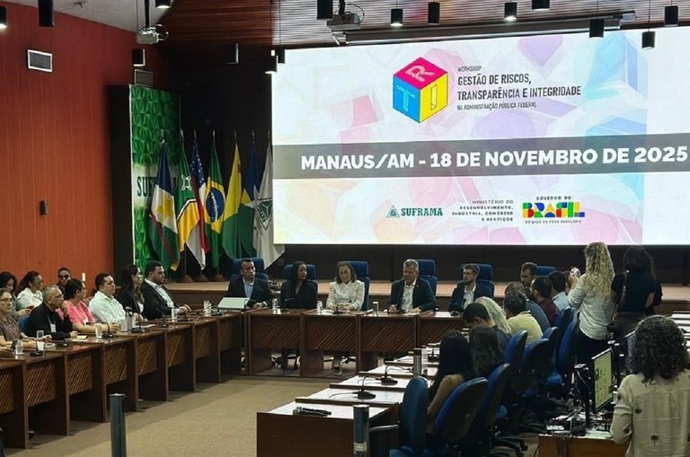 Foto motra evento num auditório com um telão ao fundo