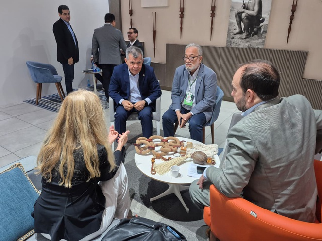 Foto mostra pessoas sentas conversando em uma reunião