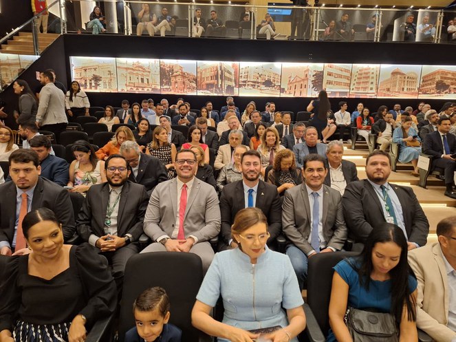 Foto mostra pessoas num auditório lotado