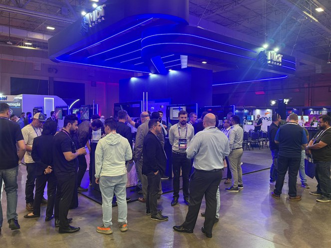 Foto mostra pessoas e estandes num grande evento