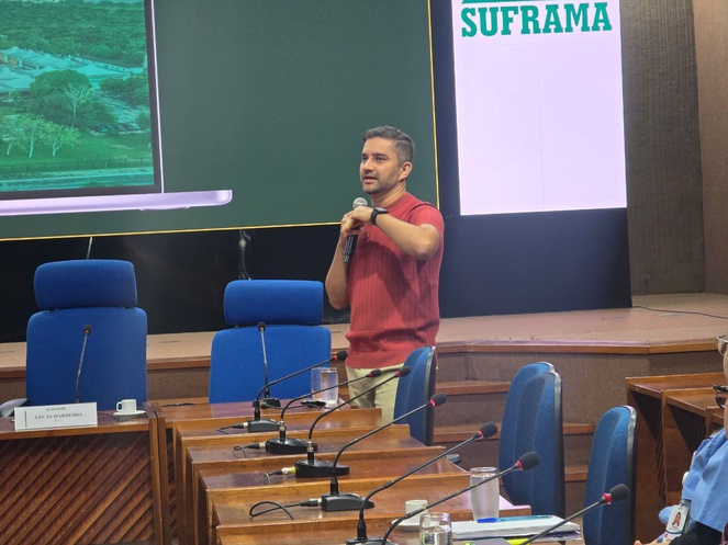 Foto mostra homem em pé falando ao microfone