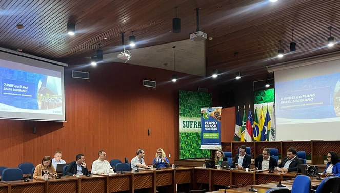 Foto mostra grupo de pessoas numa reunião e um telão ao fundo como apoio