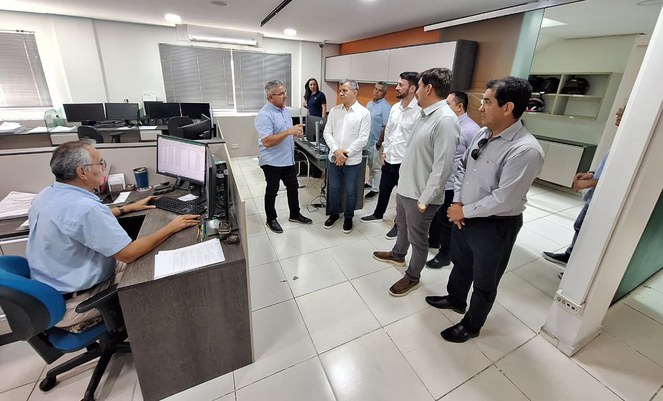 Foto mostra homens reunidos dentro de um escritório