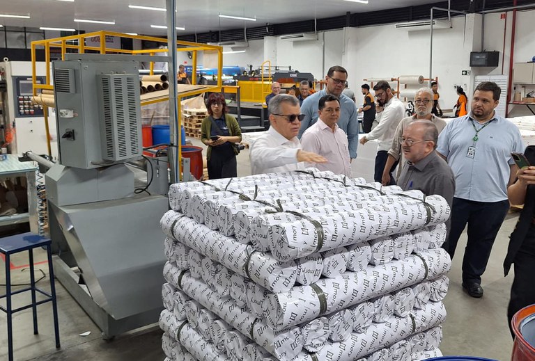 Foto mostra grupo de homens em visita a uma fábrica de