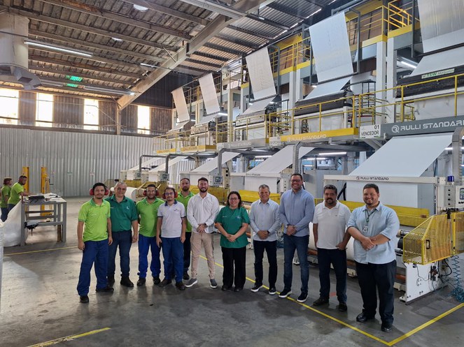 Foto mostra grupo de pessoas posando para sessão de foto numa empresa de produtos plásticos
